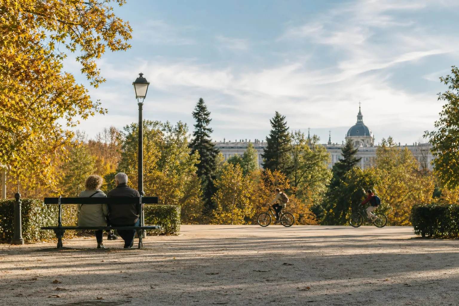 Couple on a bench in a leafy Madrid park on an autumn afternoon